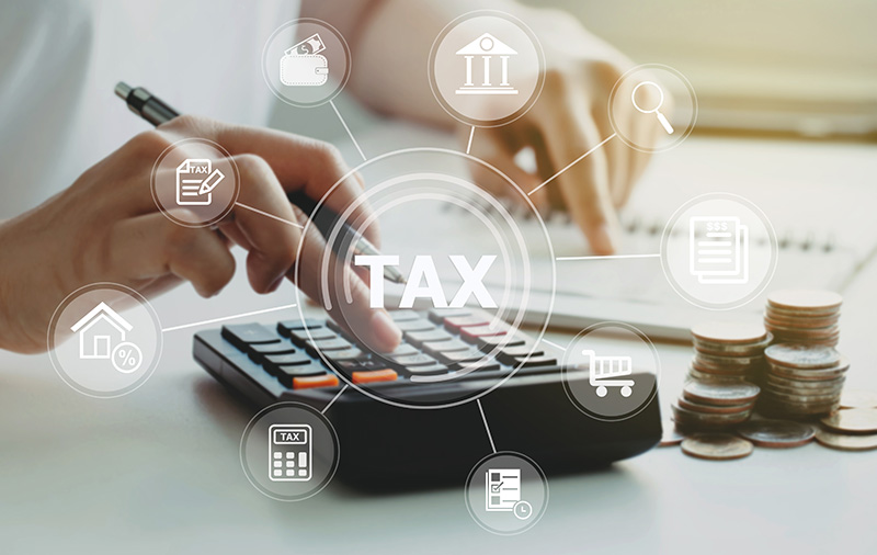 Person typing on calculator with tax graphics overlayed